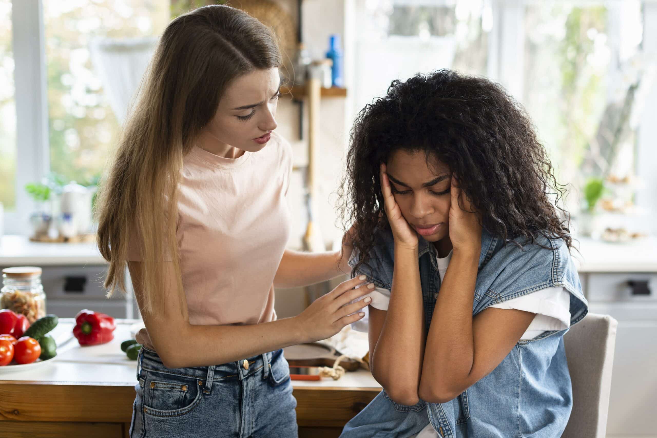 Un guide pratique pour accompagner un proche migraineux 1 woman consoling her friend kitchen scaled